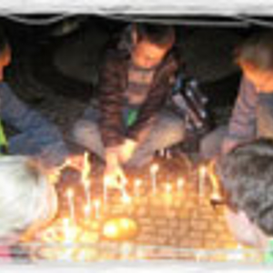 Jugendliche beim Gebet mit Kerzen.